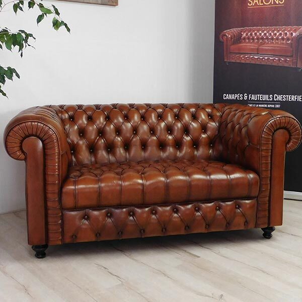 Canapé Chesterfield en cuir basane français de face. Les capitons sont réalisés sur l'assise, le dossier, les accoudoirs et la plate-bande. On retrouve l'authenticité d'une fabrication artisanale