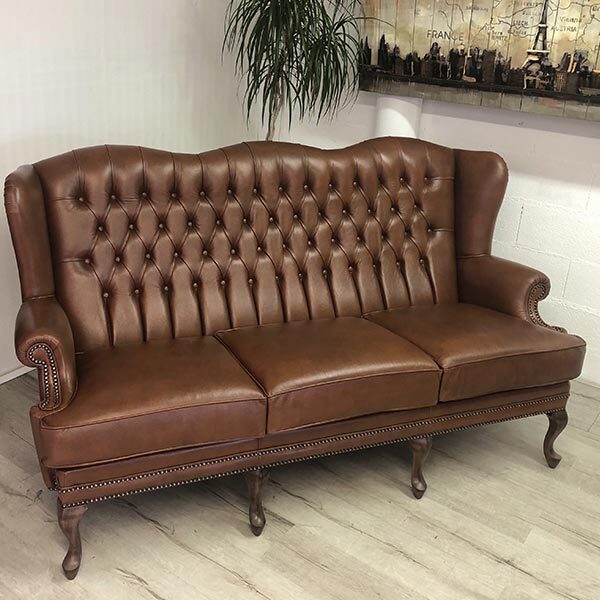 Bergère Chesterfield cuir 2 places. Les capitons sont présents sur le dossier. Les pieds sont légèrement incurvés.